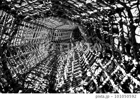 View down a long tunnel made of webbed rope at a child playground  101050592
