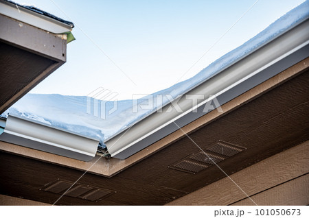 Metal gutters be installed on a residential buildings with two sections coming together for a 90 degree connection. Metal gutters be installed on a residential buildings with two sections coming together for a 90 degree connection. 101050673