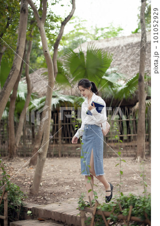 Young woman walking in the garden 101052929