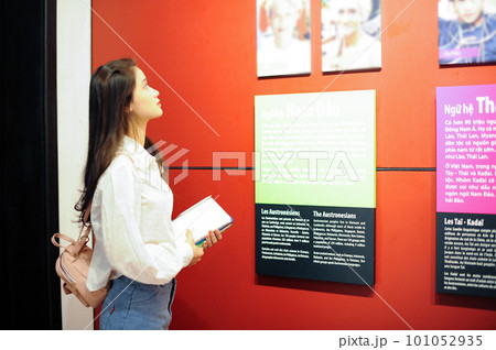 Female student looking up at an information board in the museum Female student looking up at an information board in the museum 101052935