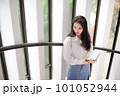 Young pretty woman holding some notebooks and looking downward 101052944