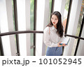 Young pretty woman holding some notebooks and looking aside 101052945