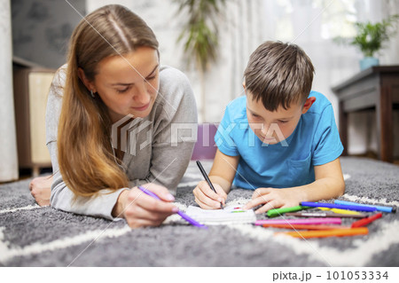Happy family playing together on floor. Mother and son painting together 101053334