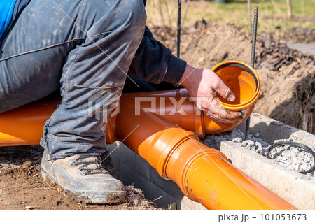 installation of a sewage plastic pipe during the construction of a house 101053673