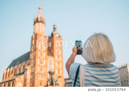 Beautiful Krakow market square, Poland, Europe. A hand taking photo of Old city center view with smartphone, Krakow, Poland 101053764