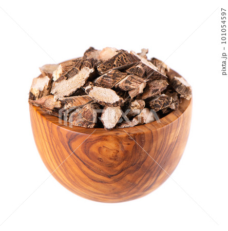 Calamus root in wooden bowl, isolated on white background. Sweet flag, sway or muskrat root. Dry root of Acorus calamus. 101054597