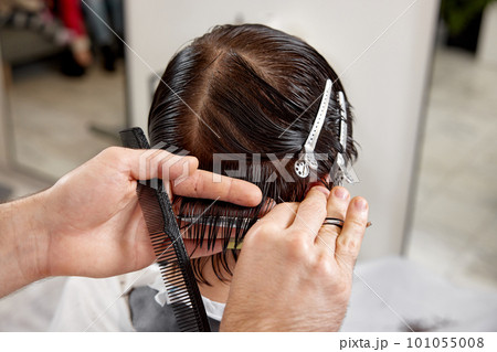 young caucasian man getting haircut by professional male hairstylist 101055008