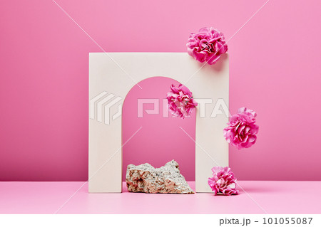 white podium with pink flowers, and arch on pastel pink background 101055087