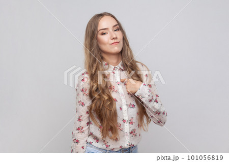 This is me. Portrait of arrogant woman with wavy blond hair pointing at herself, looking egoistic and haughty, proud of achievement. Indoor studio shot isolated on gray background. This is me. Portrait of arrogant woman with wavy blond hair pointing at herself, looking egoistic and haughty, proud of achievement. Indoor studio shot isolated on gray background. 101056819