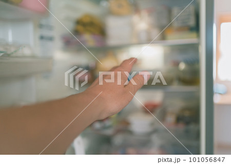 冷蔵庫を開けて何かを取ろうと 101056847