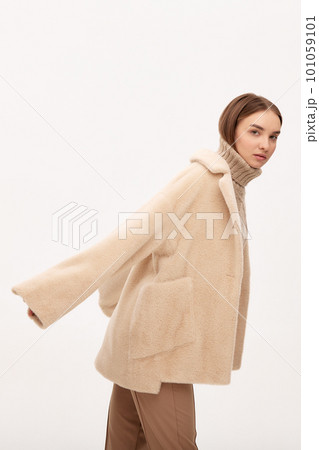 Close-up of a modern business woman on a light background in fashionable faux fur clothes, fashion, modern urban style 101059101