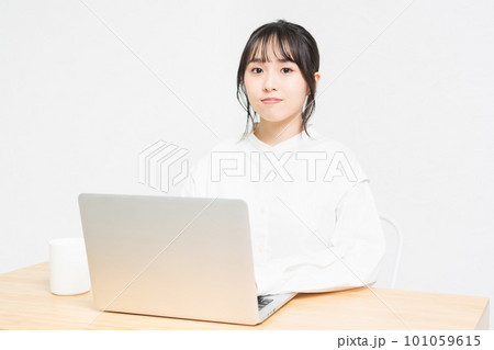白背景の前でPCを操作する若い女性 白背景の前でPCを操作する若い女性 101059615