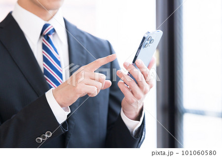 スマホを見るビジネスマンの手元 スマホを見るビジネスマンの手元 101060580