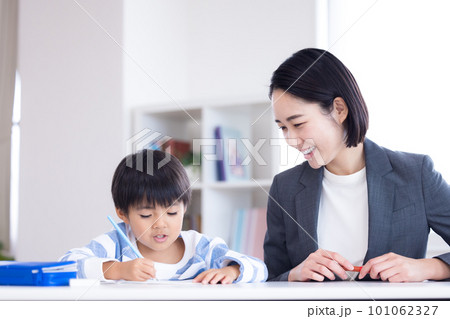 塾で勉強する小学生と先生 101062327