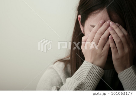 辛そうに頭を抱える若い女性 101063177