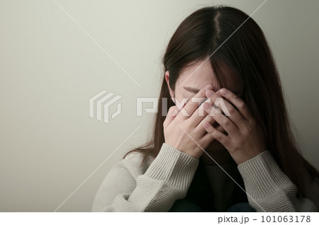 辛そうに頭を抱える若い女性 101063178
