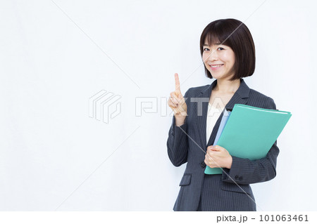 白い背景の前で人差し指を立てるスーツ姿の30代ビジネスウーマン 101063461