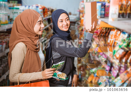 Two Muslim girls looking at nutrition table on product packaging 101063656