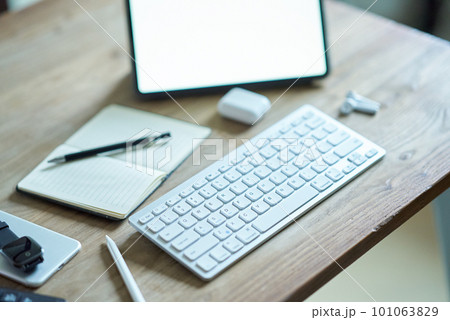 カジュアルなテーブルに置かれたタブレットPCなどビジネス道具一式 101063829