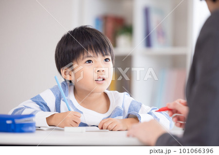 塾で勉強する小学生と先生 101066396
