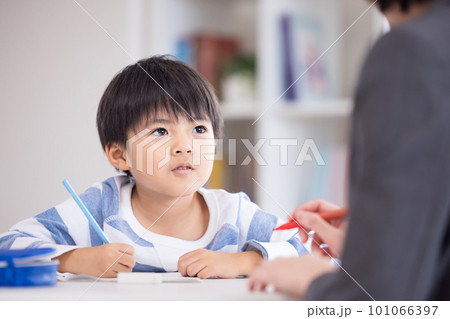 塾で勉強する小学生と先生 101066397