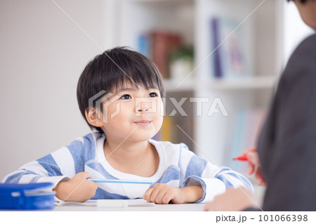 塾で勉強する小学生と先生 101066398