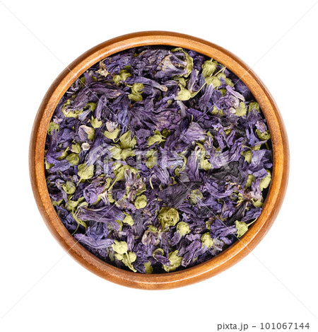 Dried purple mallow tea flowers, in a wooden bowl. Mauve-purple flower heads of Malva sylvestris, also known as common mallow, used for herbal tea and in traditional medicine. Close-up, from above. Dried purple mallow tea flowers, in a wooden bowl. Mauve-purple flower heads of Malva sylvestris, also known as common mallow, used for herbal tea and in traditional medicine. Close-up, from above. 101067144