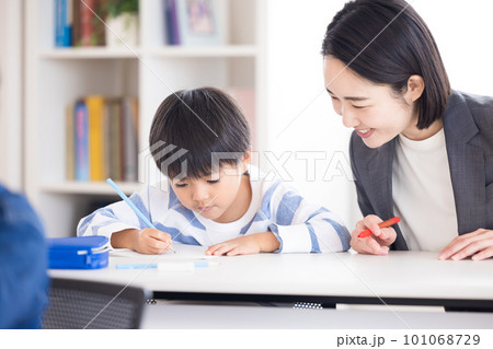 塾で勉強する小学生と先生 101068729