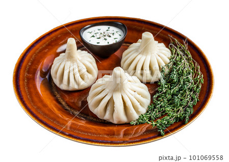 Khinkali Dumplings with beef and lamb meat on rustic plate with herbs. Isolated on white background 101069558