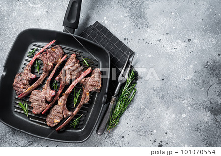 Fried on a grill skillet lamb cutlet steak, mutton rib chop. Gray background. Top view. Copy space 101070554