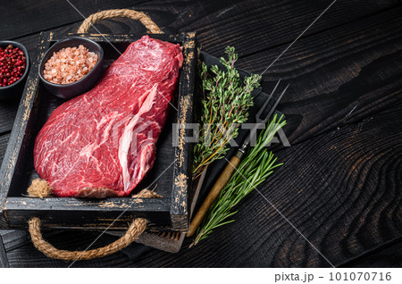 Unccoked rump steak or raw top sirloin beef meat steak. Black wooden background. Top view. Copy space 101070716