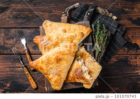 Baked samosa with chicken and cheese, samsa pies. Wooden background. Top view 101070743