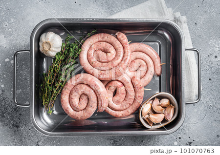 Homemade Raw spiral barbecue sausages in kitchen tray. Gray background. Top view 101070763