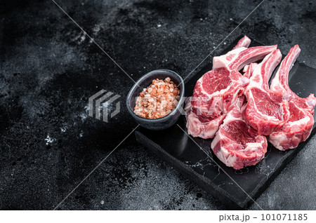 Uncooked lamb mutton chops, raw meat steaks. Black background. Top view. Copy space Uncooked lamb mutton chops, raw meat steaks. Black background. Top view. Copy space 101071185