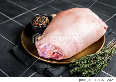 Raw pork ham hocks on a steel plate with herbs. Black background. Top view 101071282