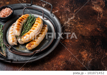 BBQ Fried Bratwurst and Chorizo sausages with herbs on a steel serving tray. Dark background. Top view. Copy space BBQ Fried Bratwurst and Chorizo sausages with herbs on a steel serving tray. Dark background. Top view. Copy space 101071452