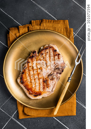 BBQ fried pork T bone chop meat steak on a plate. Black background. Top view BBQ fried pork T bone chop meat steak on a plate. Black background. Top view 101071594