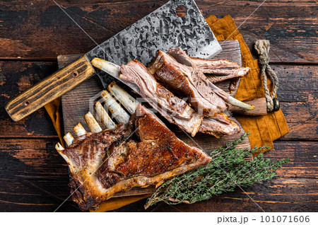 Roast lamb ribs, mutton spareribs, sliced meat on wooden board. Wooden background. Top view Roast lamb ribs, mutton spareribs, sliced meat on wooden board. Wooden background. Top view 101071606