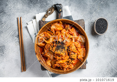 Kimchi cabbage in a wooden plate with chopsticks for eating , Korean cuisine. White background. Top view Kimchi cabbage in a wooden plate with chopsticks for eating , Korean cuisine. White background. Top view 101071619