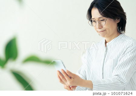 メガネをかけてスマホを見るミドル女性 メガネをかけてスマホを見るミドル女性 101071624