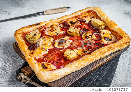 Vegetarian puff pastry pizza with artichoke, mozzarella, tomatoes and cheese. White background. Top view 101071757