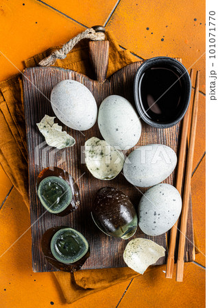 Chinese Century egg, preserved duck eggs. Orange background. Top view 101071770