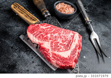 Butcher table with wagyu Rib Eye steak, raw beef meat. Black background. Top view Butcher table with wagyu Rib Eye steak, raw beef meat. Black background. Top view 101071979