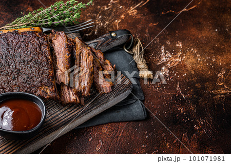 Traditional smoked barbecue wagyu beef brisket on wooden board. Dark background. Top view. Copy space Traditional smoked barbecue wagyu beef brisket on wooden board. Dark background. Top view. Copy space 101071981