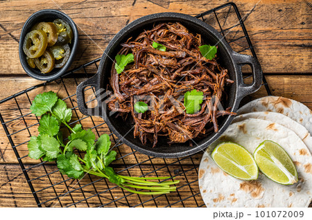 Cooking of mexican pork carnitas taco. Wooden background. Top view Cooking of mexican pork carnitas taco. Wooden background. Top view 101072009
