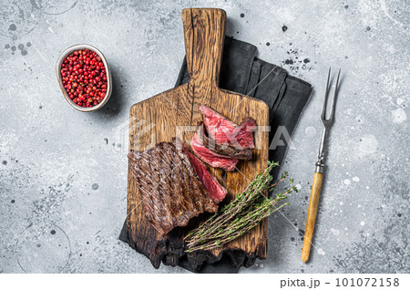 BBQ Grilled Wild Venison steak on wooden board. Gray background. Top view BBQ Grilled Wild Venison steak on wooden board. Gray background. Top view 101072158