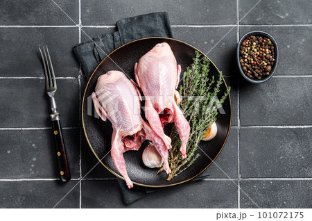 Fresh organic quails, raw poultry with herbs. Black background. Top view Fresh organic quails, raw poultry with herbs. Black background. Top view 101072175