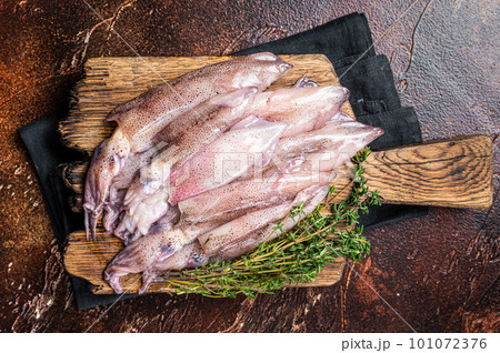 Fresh squid on cutting board, raw Seafood. Dark background. Top view 101072376