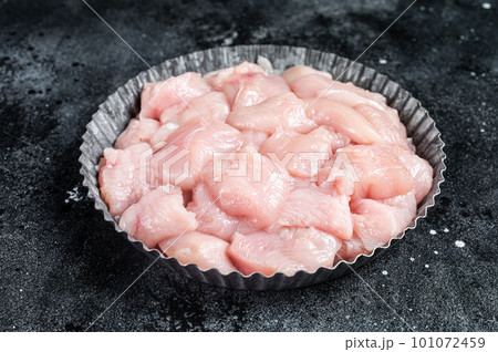 Diced raw chicken breast fillets on a plate, poultry meat. Black background. Top view Diced raw chicken breast fillets on a plate, poultry meat. Black background. Top view 101072459
