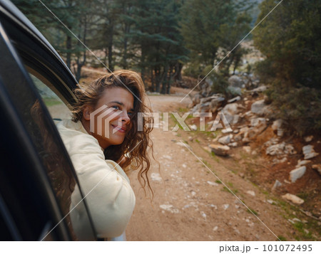 Woman on road trip traveling by rental car 101072495